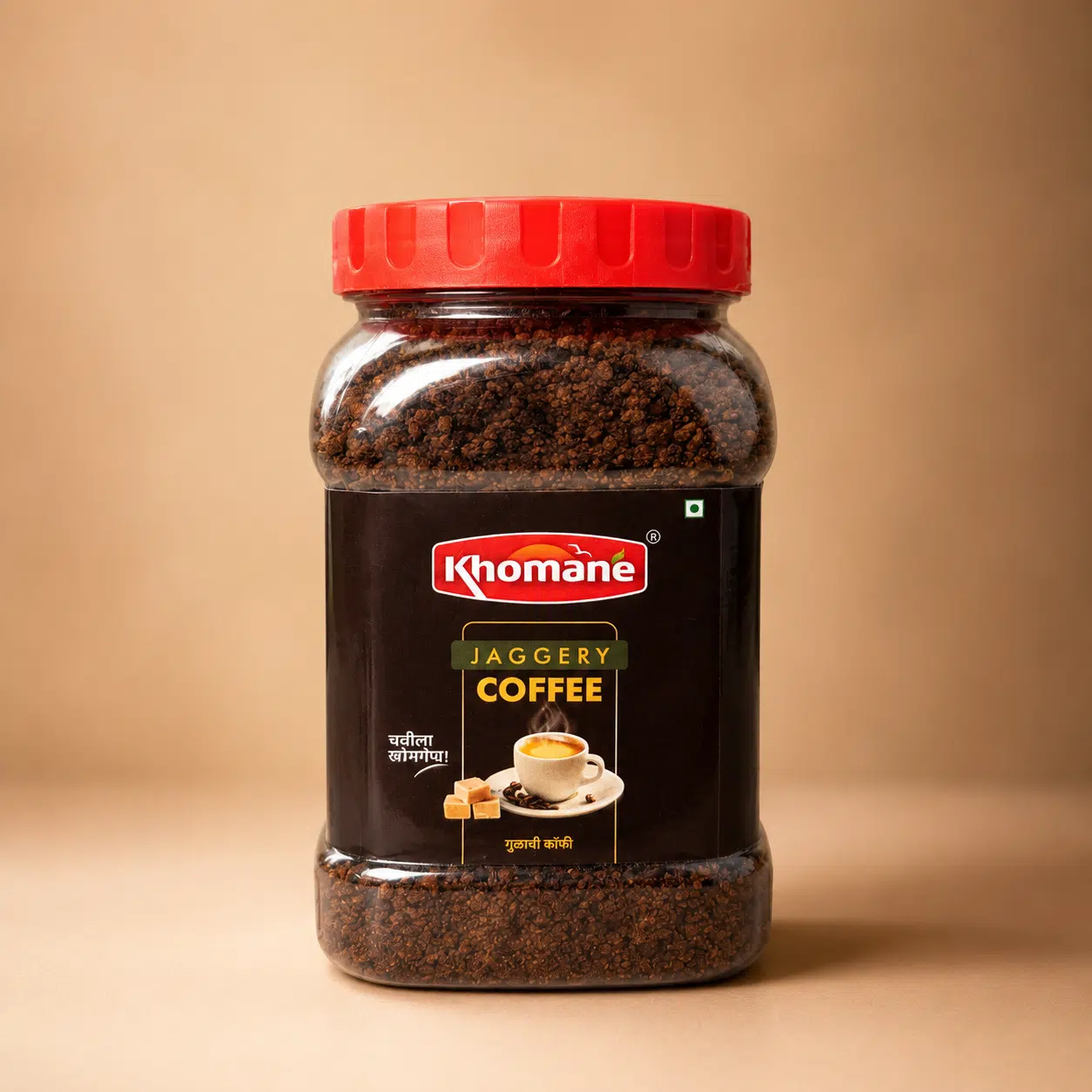 Khomaane Jaggery Coffee jar with a red lid, showing coffee granules and a cup of coffee.
